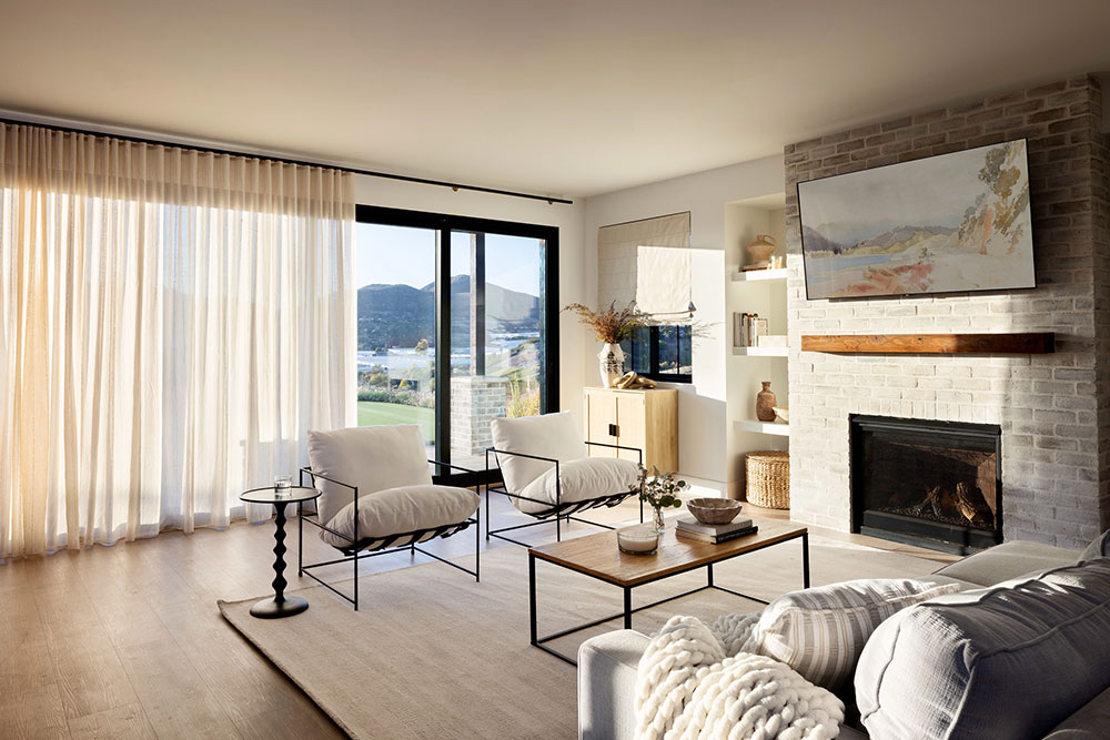 Sheer Ripplefold Drapery over sliding glass doors in a living room at sunset.