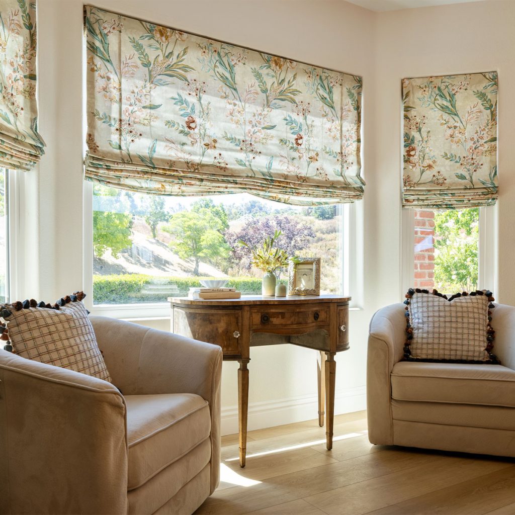 Soft Roman Shades with a large scale botanical print in a sitting area's bay window.