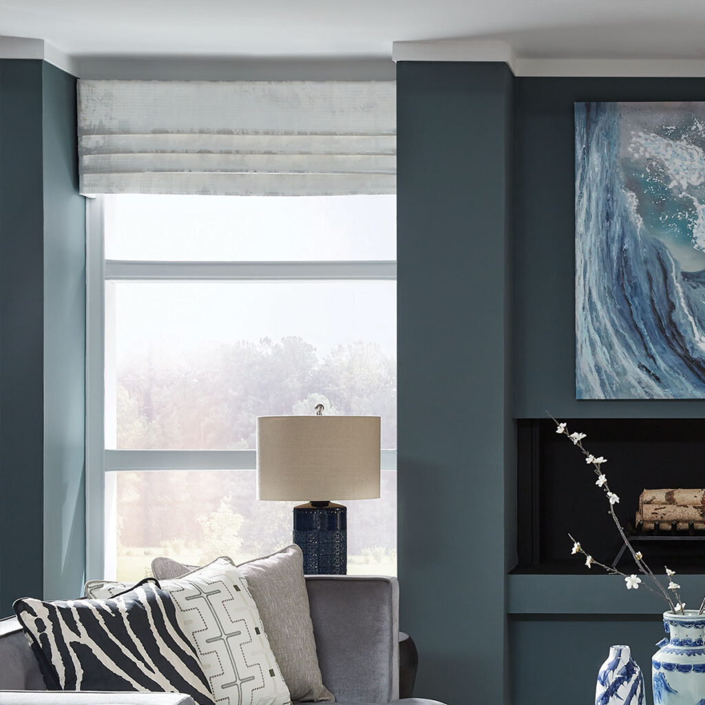 White Welles Board Mounted Valance top treatment over a tall window in a medium blue living room.