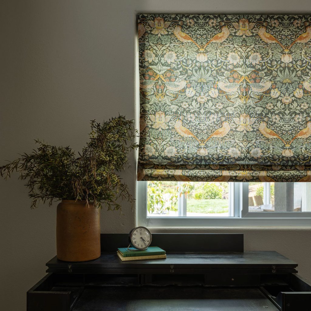 A Flat Roman Shade that's mostly closed to highlight an intricately patterned fabric.